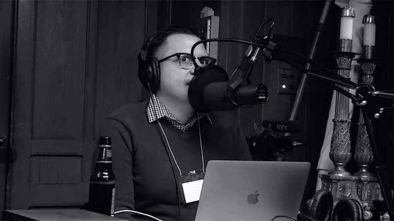 Black and white photo of Scott Jones at the mic.