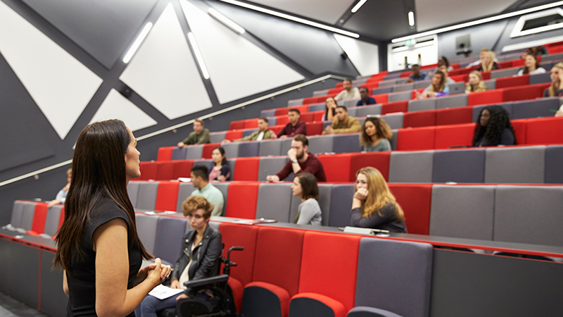 Woman teaching in auditorium style classroom.
